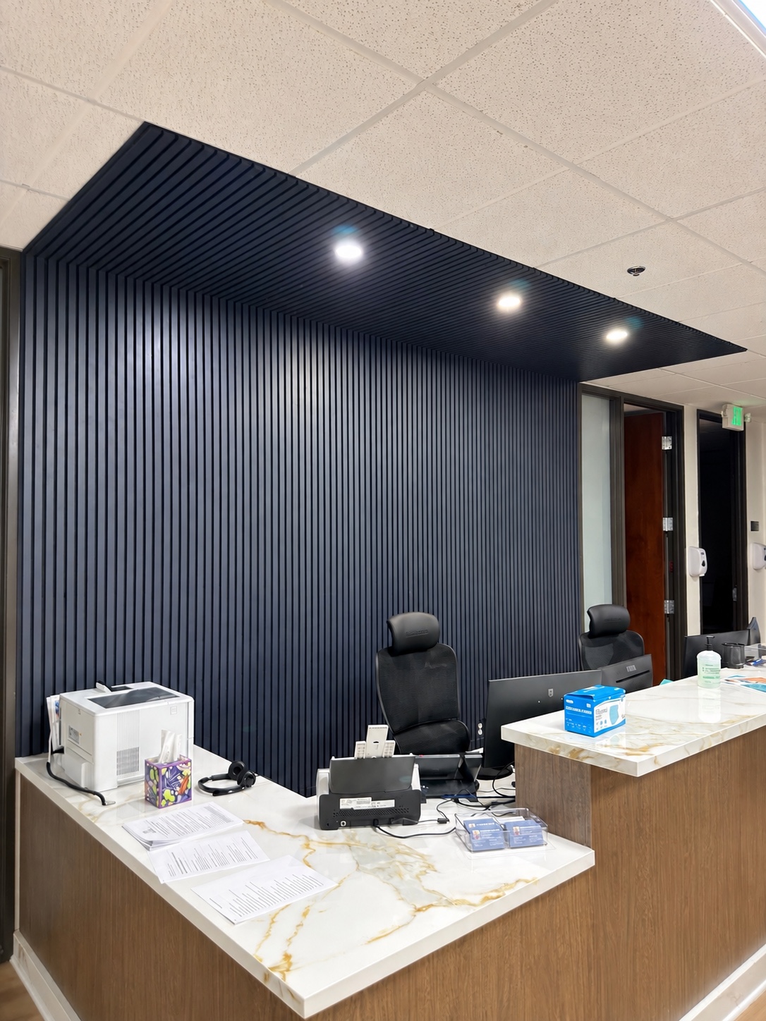 Completed dark slat wall and ceiling panel installation